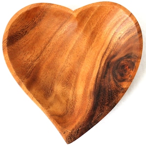 Può includere: Una ciotola di legno a forma di cuore realizzata in legno di acacia. La ciotola ha una finitura in legno naturale e una superficie liscia.