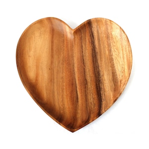 Può includere: Un vassoio da portata in legno a forma di cuore con finitura in legno naturale. Il vassoio è realizzato in legno di acacia e ha una superficie liscia e lucida.