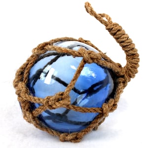 Könnte beinhalten: Ein blauer Glas-Schwimmer mit einem dicken Seilnetz darum. Das Seil ist braun und hat eine Schlaufe oben.