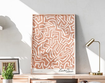 Könnte beinhalten: Ein heller Holzschreibtisch mit einem Stuhl, einer Lampe und einem gerahmten abstrakten Druck mit weißen Linien auf einem pfirsichfarbenen Hintergrund. Der Druck ist mit "Composition No. 1" betitelt und von "Alberto Odriozola" signiert.