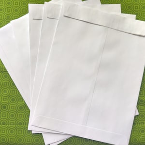 May include: A stack of five white envelopes on a green patterned surface.