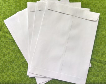 May include: A stack of five white envelopes on a green patterned surface.