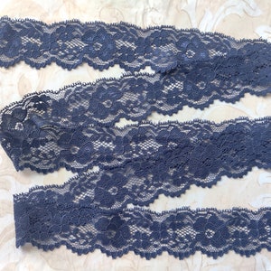 May include: Four pieces of dark gray lace trim with a floral pattern.