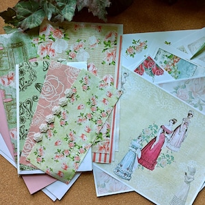 May include: A collection of decorative paper sheets featuring floral patterns, rose motifs, and illustrations of figures in historical attire. The set includes various textures and designs in shades of green, pink, and white, with some sheets displaying intricate scrollwork and small white embellishments.