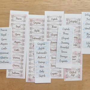 May include: A collection of decorative labels with various words in a vintage style. The labels feature words like "Princess", "Royal", "Elegant", and "Gorgeous" in a decorative font, with floral and ornate borders.