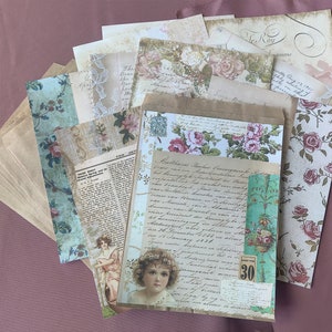 May include: A collection of vintage-style paper ephemera, including envelopes, patterned papers with floral and script designs, and a newspaper clipping. The color palette includes beige, pink, and teal, creating a nostalgic aesthetic.