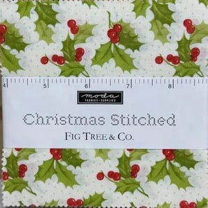 May include: A stack of fabric squares with a Christmas holly print. The fabric features green holly leaves and red berries on a white background. The text "Christmas Stitched" and "Fig Tree & Co." are visible.