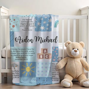 May include: A blue and white patchwork baby blanket with the names Aiden Michael and bible verses. The blanket features a sun, ABC blocks, and a rainbow.