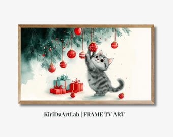 May include: A gray and white kitten hangs from a Christmas tree decorated with red and white ornaments. The kitten is looking up at the ornaments with a playful expression. There are also wrapped presents under the tree.
