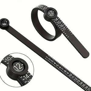 May include: Black ring sizer tool with a circular ring and a straight ruler-like section. The tool has white numbers and markings for ring sizes. The ring sizer tool is used to measure finger size for rings.