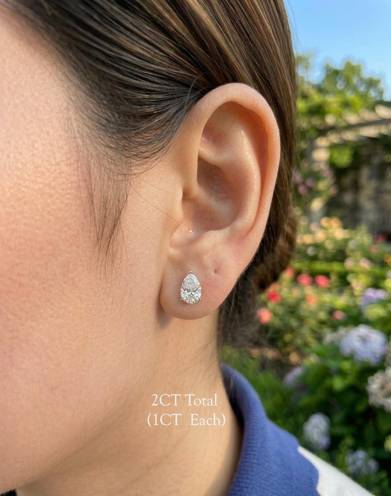 May include: A white ceramic mug with a black handle and the text "But First, Coffee" in a handwritten style. The mug is on a white surface. The mug is approximately 4 inches tall.