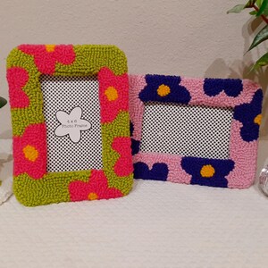 Set of handmade punch needle 4x6 picture frames featuring colorful daisy designs. Crafted with soft yarn, these frames add a cozy vibe to any space. Perfect for displaying cherished photos or as a unique decorative piece. Not wall-mounted.