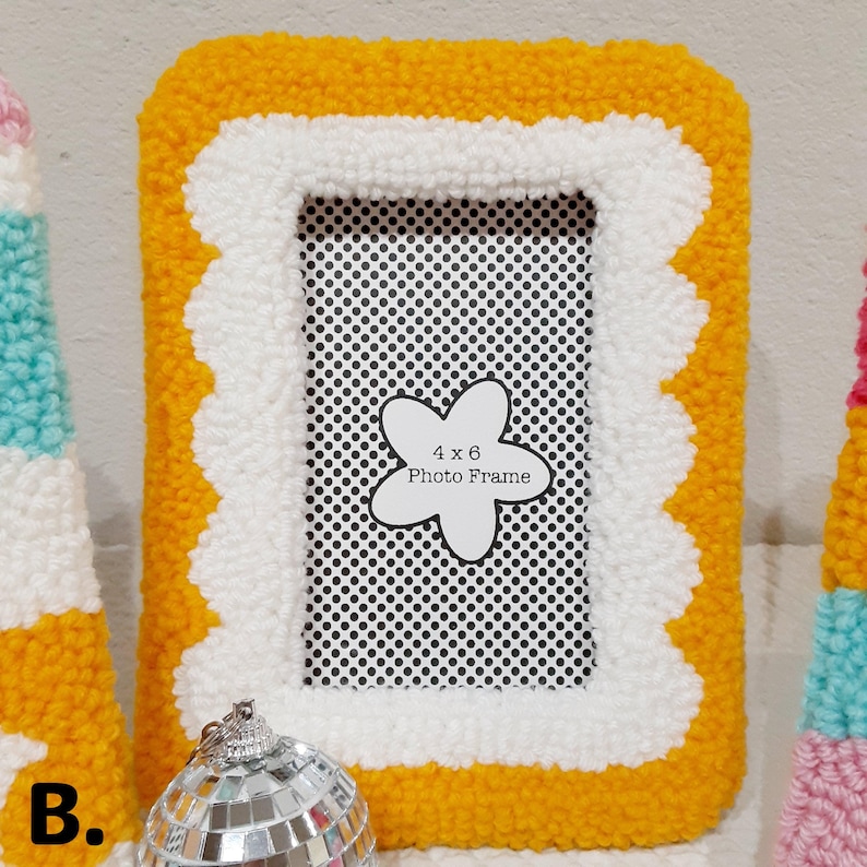 Colorful handmade punch needle photo frames in bright pink, yellow, blue, and white yarn. These 4x6 hand-tufted picture frames are perfect for fun, playful decor. Cozy textured frame designs ideal for desk styling, room decor, or unique gifts.