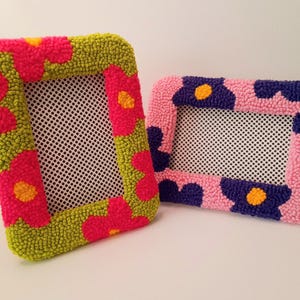 Set of handmade punch needle 4x6 picture frames featuring colorful daisy designs. Crafted with soft yarn, these frames add a cozy vibe to any space. Perfect for displaying cherished photos or as a unique decorative piece. Not wall-mounted.