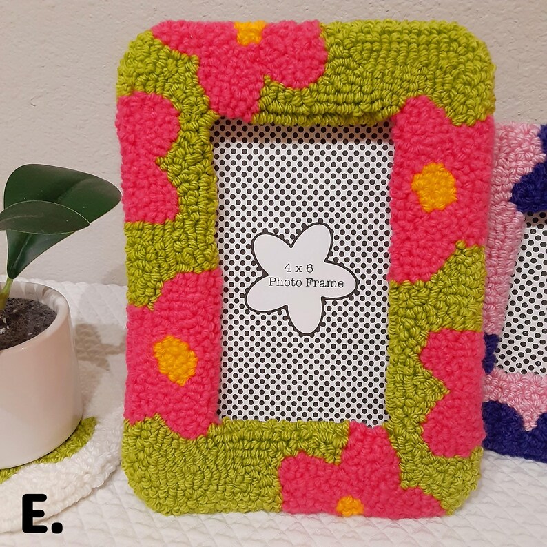 May include: A green and pink photo frame with a 4x6 inch opening. The frame is decorated with a floral pattern and has a white label that says "4x6 Photo Frame".