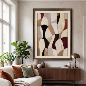 Può includere: Una grande opera d'arte da parete incorniciata di forma rettangolare che presenta una composizione astratta di forme organiche intrecciate in una tavolozza di crema, beige, marrone chiaro, marrone scuro, nero e bordeaux, in una cornice metallica.