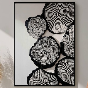 Könnte beinhalten: Abstraktes Kunstwerk in Schwarz und Weiß mit Baumring-Designs. Das Kunstwerk ist in einem schwarzen Rahmen gefasst. Die Baumringe sind in verschiedenen Größen auf einem weißen Hintergrund angeordnet.