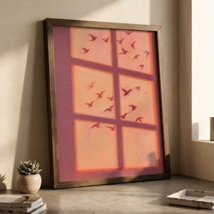 Peut inclure: Une œuvre d'art murale rectangulaire encadrée présentant un fond aux tons chauds de coucher de soleil avec une superposition de carreaux de fenêtre. Des silhouettes sombres d'oiseaux en vol sont dispersées sur le ciel orange et rose.