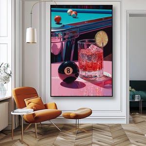 May include: A colourful painting shows a pool table with balls and a glass of red liquid with ice and a lime slice. A black eight ball is in front of the glass. The artwork is set on a pink surface.
