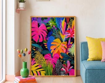Puede incluir: Una impresión artística enmarcada con un diseño botánico vibrante y colorido. La obra de arte muestra hojas grandes y estilizadas en tonos de rosa, amarillo, azul y verde sobre un fondo negro. La impresión se exhibe en una habitación con un sofá azul y un jarrón verde.