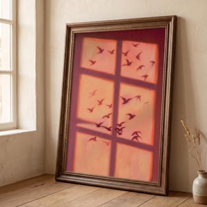 Könnte beinhalten: Ein rechteckiges gerahmtes Wandbild mit einem warmen, sonnenuntergangsfarbenen Hintergrund und einer gitterartigen Fensterüberlagerung. Dunkle Silhouetten zahlreicher Vögel im Flug sind über die Scheiben verteilt und erzeugen einen Schichteffekt.
