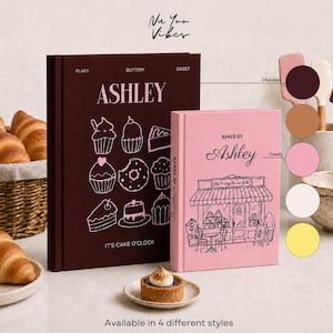 Può includere: Due libri di ricette con copertina rigida intitolati Ashley, uno marrone scuro con disegni bianchi di prodotti da forno e il testo It's Cake O'Clock, e uno rosa chiaro con l'illustrazione di una panetteria. Include un cesto di croissant e una crostatina.