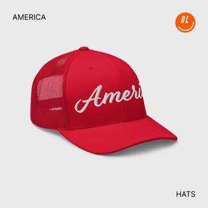 Könnte beinhalten: Rote Trucker-Cap mit dem Wort "Ameri" in weißer Schrift gestickt. Die Cap hat einen Mesh-Rücken und einen gebogenen Schirm. Das Wort "AMERICA" steht über der Cap und "HATS" darunter.