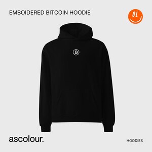 Puede incluir: Sudadera negra con el logotipo de Bitcoin bordado en blanco en el pecho. La sudadera con capucha tiene una capucha y un bolsillo delantero. El texto "EMBOIDERED BITCOIN HOODIE" está en la parte superior de la imagen. La marca "ascolour." está en la parte inferior.
