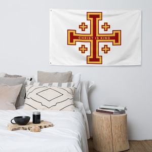 Könnte beinhalten: Weiße Flagge mit einem rot-goldenen Jerusalemer Kreuz-Design und dem Text "CHRIST IS KING". Die Flagge hängt an einer weißen Wand über einem Bett mit dekorativen Kissen und einem hölzernen Beistelltisch.