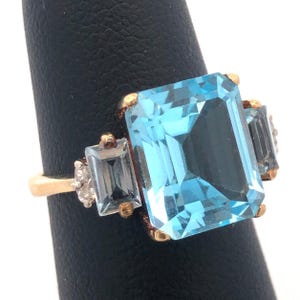 Anillo de cóctel con diseño de aniversario de diciembre, en oro amarillo de 14 quilates y diamantes con topacio azul