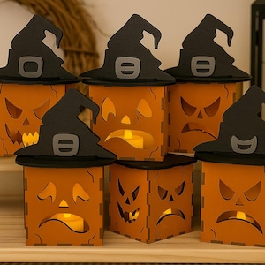 Pode incluir: Uma coleção de lanternas de Halloween laranja com rostos de abóbora esculpidos e chapéus de bruxa pretos. Cada lanterna tem uma expressão facial diferente e contém uma vela LED cintilante, criando um ambiente assustador.