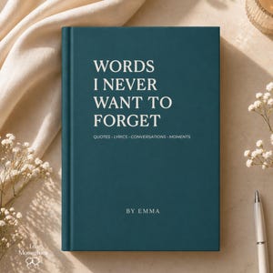 May include: A teal hardcover journal with the text "WORDS I NEVER WANT TO FORGET" in white. The journal also includes the text "QUOTES · LYRICS · CONVERSATIONS · MOMENTS" and "BY EMMA". A white pen and flowers are next to the journal.
