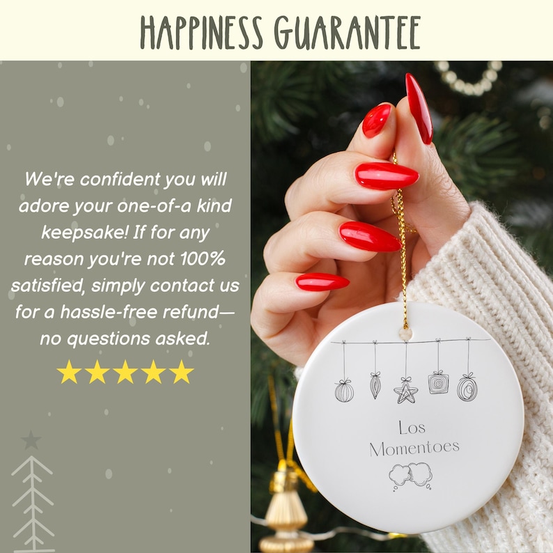 May include: A white ceramic ornament with a gold string, held by a hand with red nails. The ornament has a line of sketched holiday decorations and the text "Los Momentoes". The text "HAPPINESS GUARANTEE" is at the top.