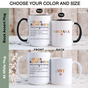 Puede incluir: Taza de cer&aacute;mica blanca con borde y asa negros. La taza presenta un dise&ntilde;o gr&aacute;fico colorido con el texto "HUMAN RESOURCES" y una definici&oacute;n. La parte posterior de la taza tiene el nombre "JOY" en texto colorido.