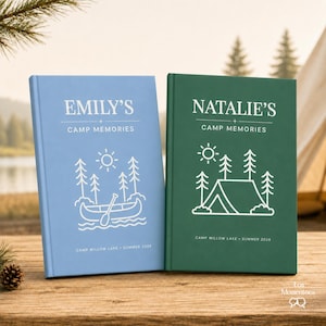 May include: Two hardcover journals, one light blue and one dark green, with white text and illustrations. The blue journal reads "EMILY'S CAMP MEMORIES" with a canoe graphic. The green journal reads "NATALIE'S CAMP MEMORIES" with a tent graphic. Both say "CAMP WILLOW LAKE - SUMMER 2020" and "CAMP WILLOW LAKE - SUMMER 2026".