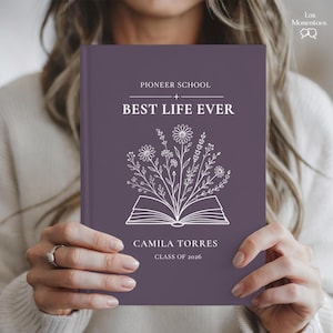 May include: A purple journal with the text "PIONEER SCHOOL BEST LIFE EVER" and the name "CAMILA TORRES CLASS OF 2026". The cover features a floral design emerging from an open book.