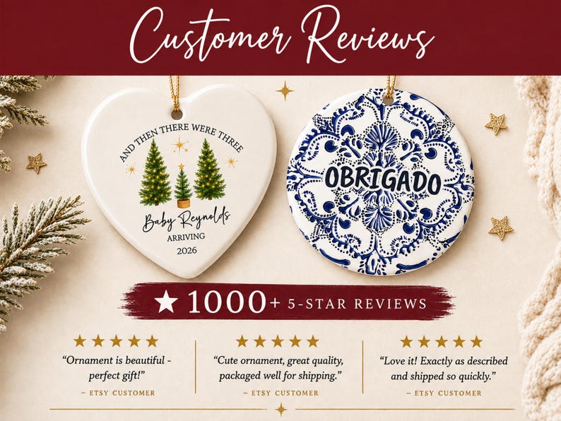 May include: Two ceramic ornaments, one heart-shaped and one circular. The heart ornament features three green Christmas trees, gold stars, and text reading AND THEN THERE WERE THREE Baby Reynolds ARRIVING 2026. The circular ornament has a blue and white floral pattern and the word OBRIGADO.