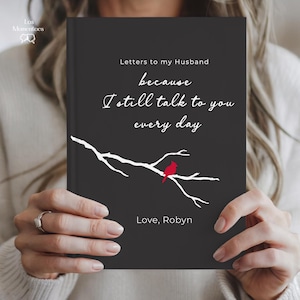 May include: A black journal titled "Letters to my Husband" with white script and a branch design with a red cardinal. The cover includes the text "because I still talk to you every day" and "Love, Robyn."