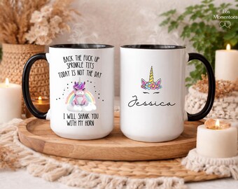 May include: Two white ceramic mugs with black handles and rims. One mug features a unicorn graphic with text: "Back the fuck up sprinkle tits today is not the day. I will shank you with my horn." The other mug has a unicorn graphic and the name "Jessica".