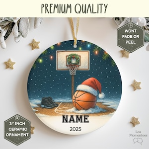 May include: A 3-inch ceramic Christmas ornament featuring a basketball court scene with a basketball wearing a Santa hat. The ornament has the text "NAME" and "2025". The background is a snowy night scene with a basketball hoop and a pair of sneakers.