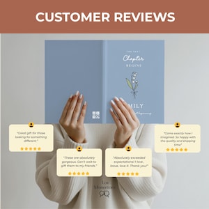 May include: A pale blue journal featuring the text "The Next Chapter Begins" and a floral design. The journal is held by a person. Customer reviews are displayed below the journal.