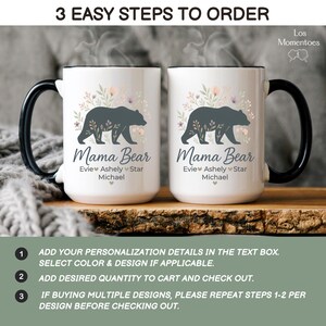 May include: Two white ceramic Mama Bear mugs with black handles and rims. Each mug features a dark gray bear silhouette surrounded by floral accents and the text "Mama Bear" with personalized names below. The image also includes ordering instructions.