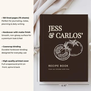 May include: A dark brown hardcover recipe book with a matte finish, featuring the text JESS & CARLOS' RECIPE BOOK from our kitchen with love and a white line drawing of two tomatoes. The book measures 8.07 inches by 5.71 inches with casewrap binding.