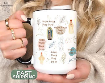 May include: White ceramic mug with a black rim and handle. The mug features a colorful design with illustrations of the Virgin Mary and the text "Virgin Mary Pray for us".