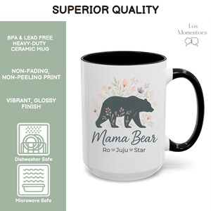 May include: White ceramic mug with a black interior and handle. The mug features a dark gray bear silhouette with floral accents and the words "Mama Bear" below. The mug is dishwasher and microwave safe.
