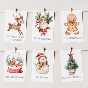Può includere: Sei biglietti a tema natalizio appesi a una corda. Ogni biglietto presenta un'illustrazione ad acquerello e testo: renna, Babbo Natale, omino di pan di zenzero, palla di neve, pupazzo di neve e albero di Natale. Il testo include: "Prepara il cibo per le renne," "Fai foto con Babbo Natale."