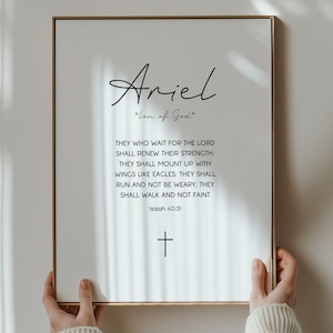 May include: A printable wall art design featuring the name "Ariel" with the phrase "Lion of God" and a Bible verse from Isaiah 40:31. The design is in black text on a white background.