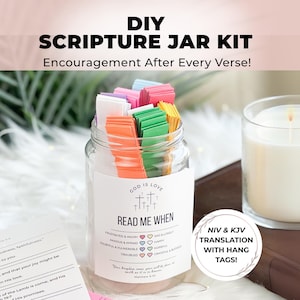 May include: DIY Scripture Jar Kit with colourful paper strips in a glass jar. The jar has a label that says "God is Love" and "Read Me When". The label also includes a list of emotions and corresponding heart icons. The kit includes NIV and KJV translations with hang tags.