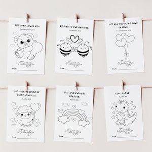 Puede incluir: Seis tarjetas de San Valentín colgadas de una cuerda, cada una con una ilustración diferente en blanco y negro. Las tarjetas presentan un oso de peluche, abejas, corazones, una oveja, un arcoíris y un dinosaurio. Cada tarjeta tiene un versículo bíblico y espacio para escribir "de:" y "Feliz Día de San Valentín."