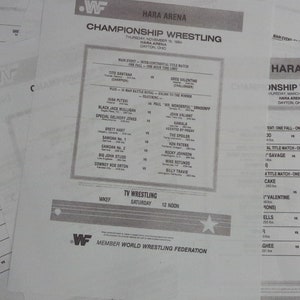 May include: A black and white wrestling event flyer for the Hara Arena in Dayton, Ohio. The flyer lists the matches for the event, including the main event, which is a title match between Tito Santana and Greg Valentine. The flyer also includes the date and time of the event.